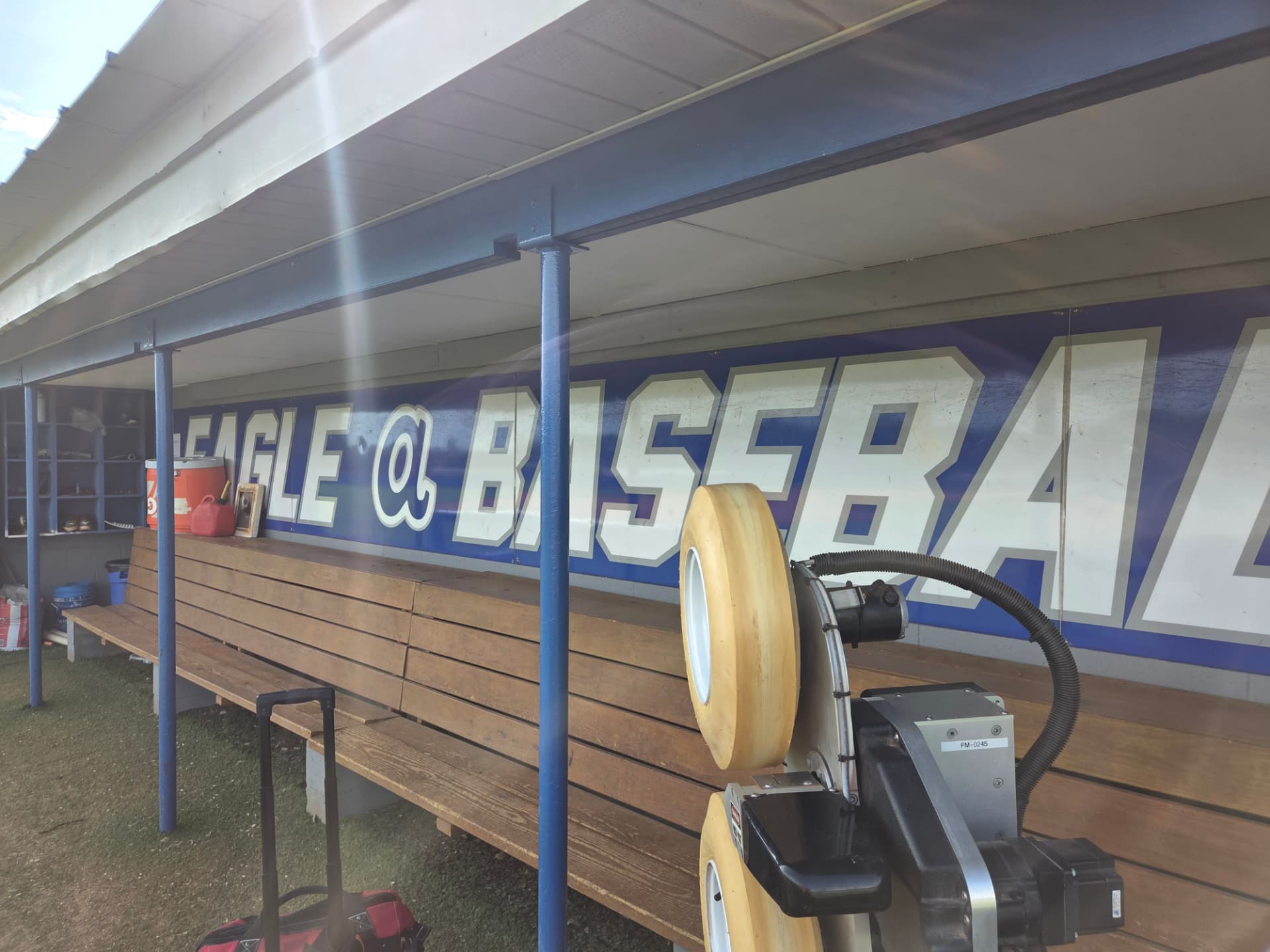 Machine wheel assembly in front of a baseball dugout